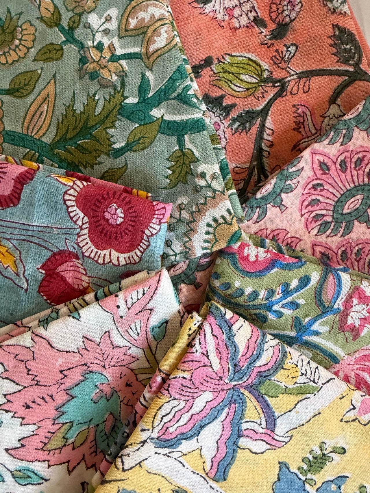 Collection of colorful floral and nature-themed fabric swatches.