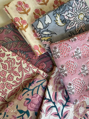 Collection of patterned fabrics with floral and abstract designs.