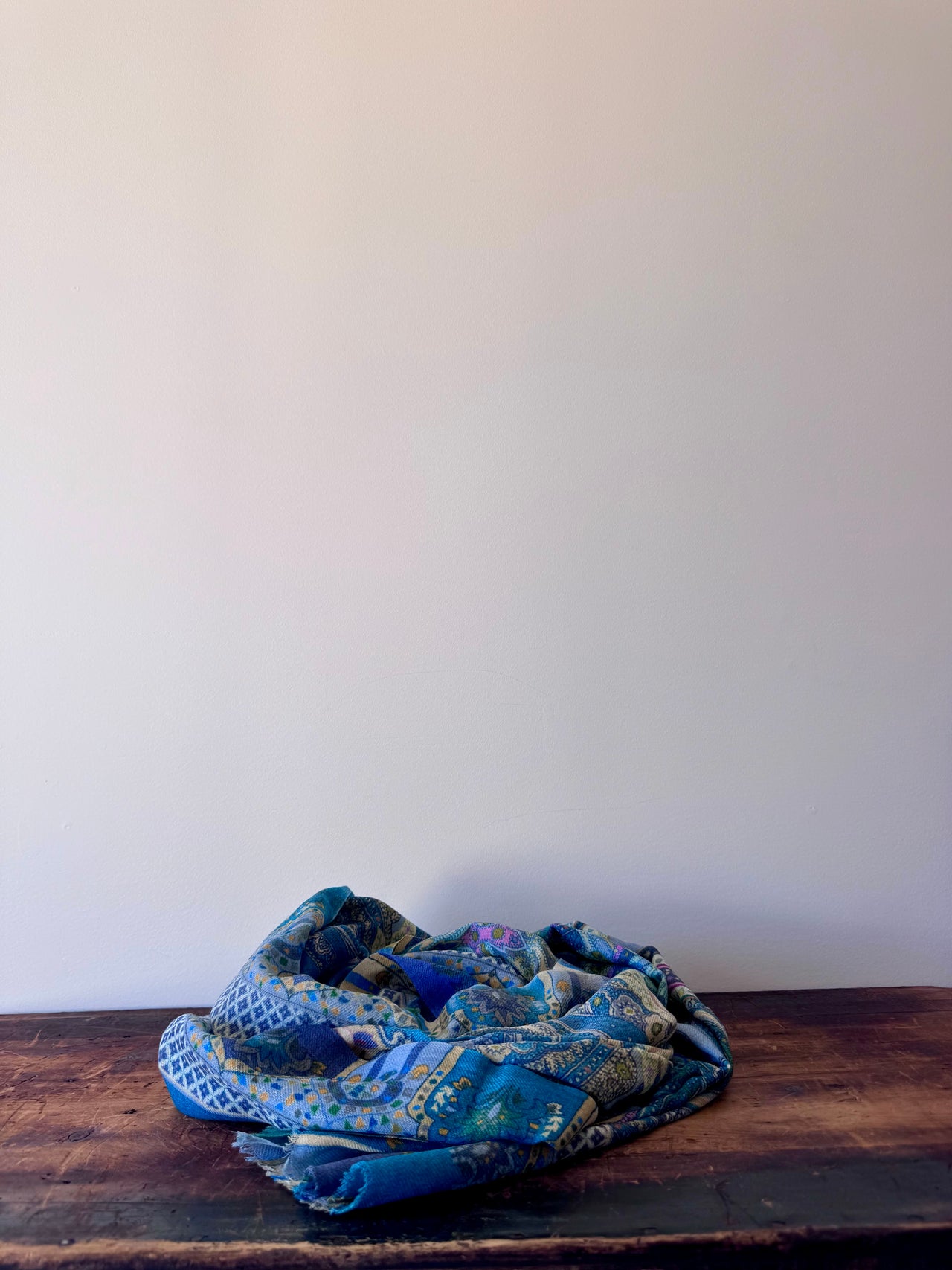 Blue patterned fabric on a wooden surface with a white background