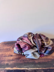 Folded fabric on a wooden surface with a white background