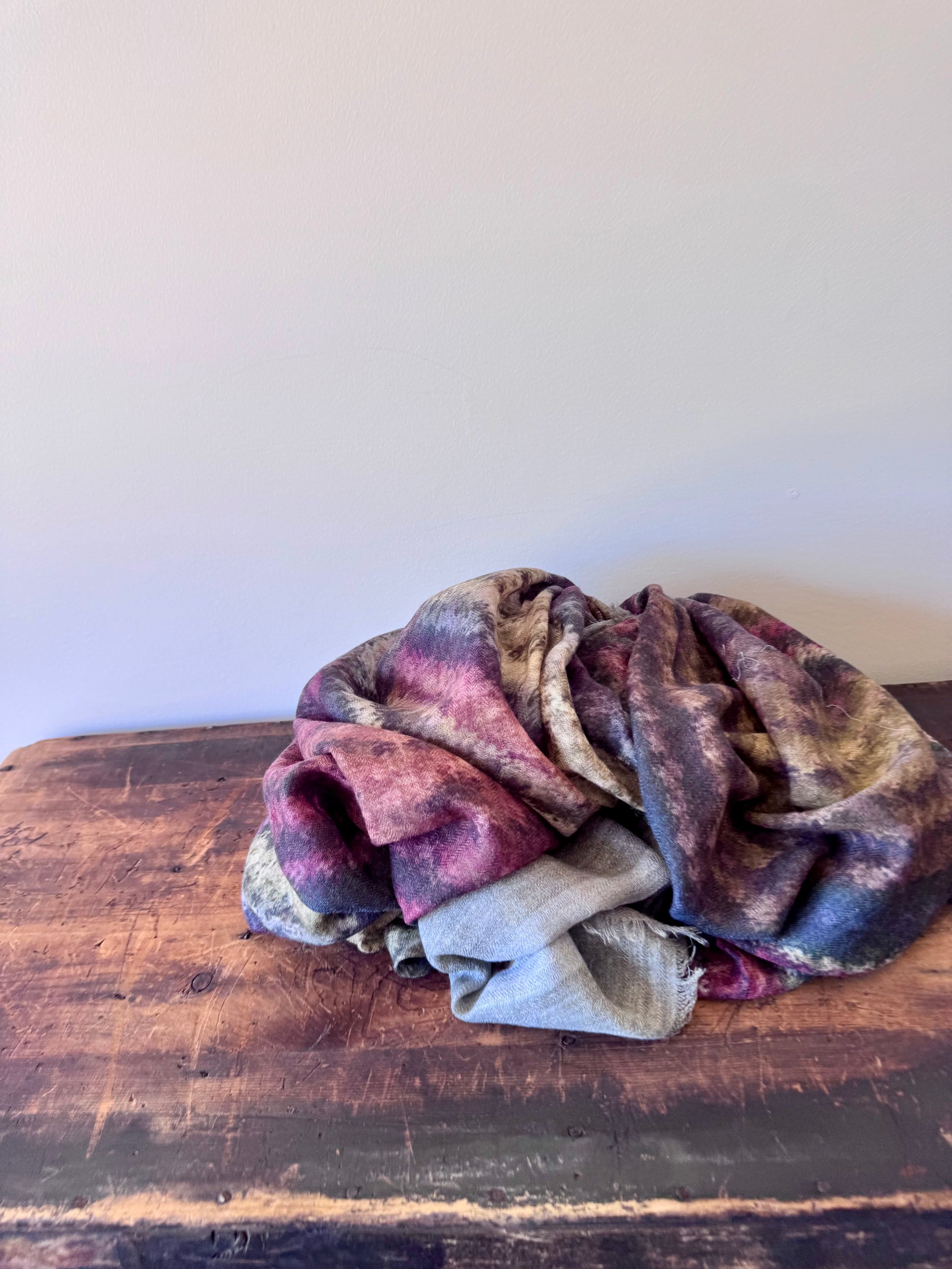 Folded fabric on a wooden surface with a white background