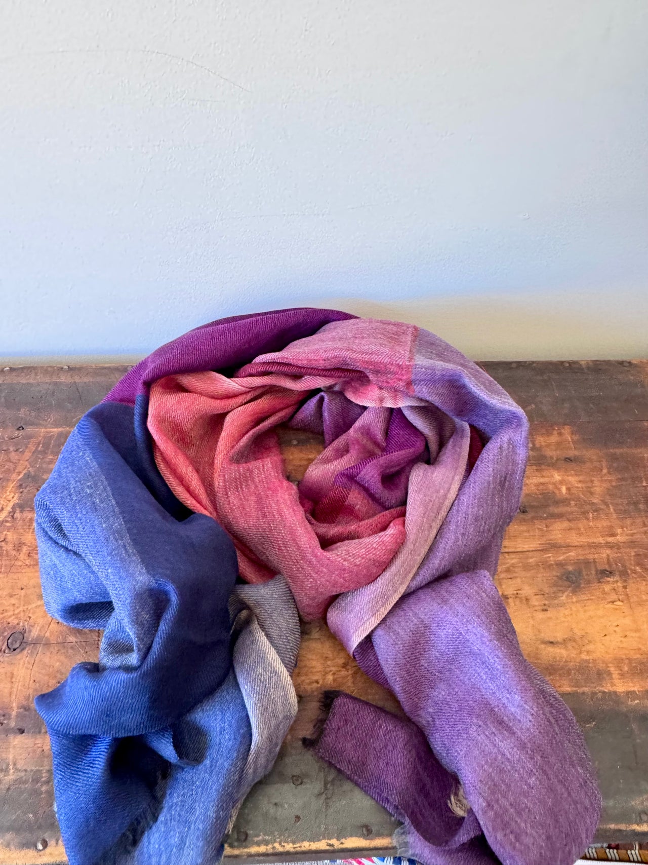 Folded fabric with gradient colors on a wooden surface