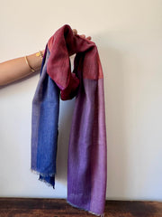 Two scarves, one blue and one purple, draped over a mannequin arm against a white background.
