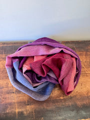 Folded fabric with purple, pink, and blue gradient on a wooden surface