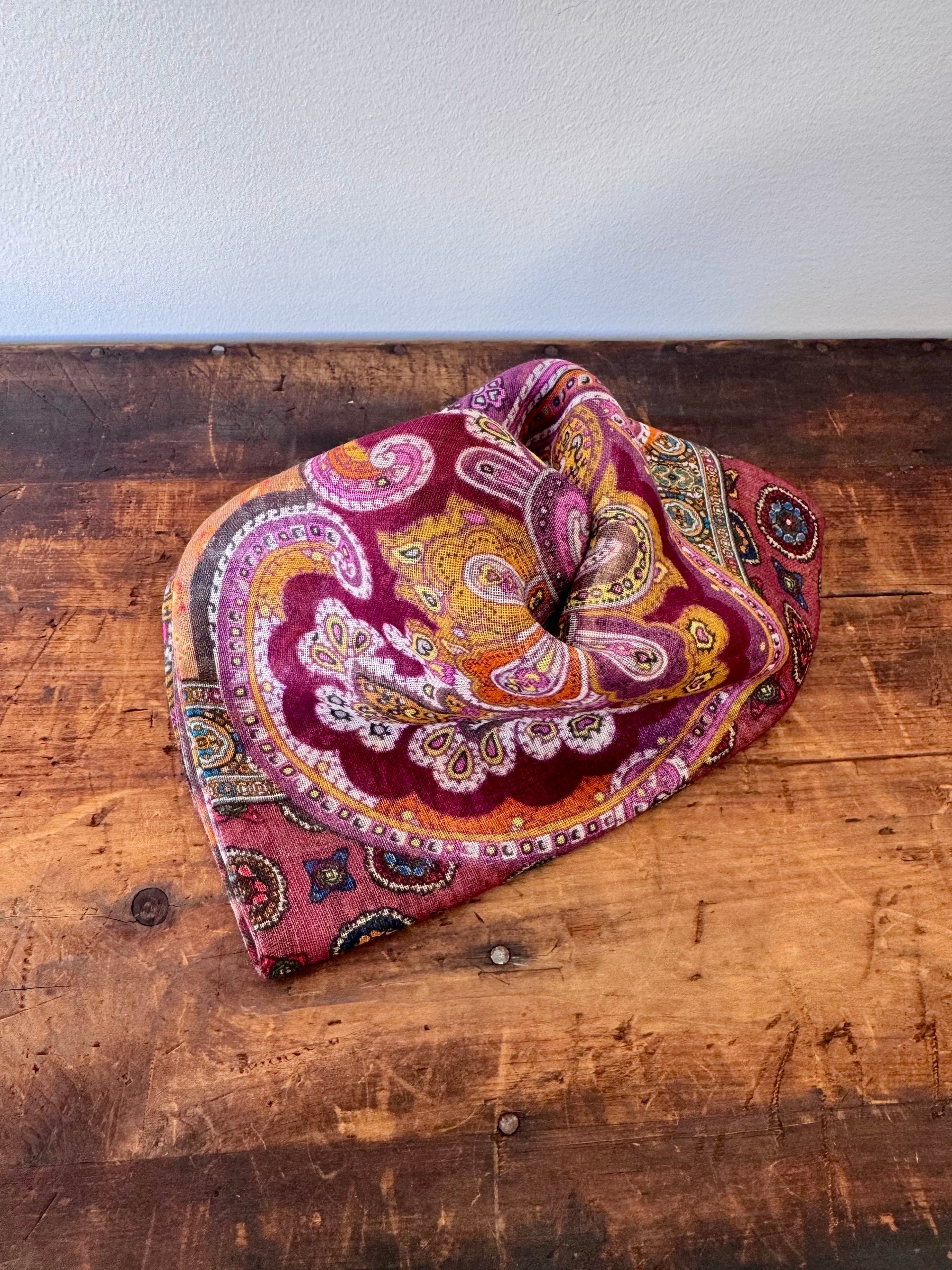 Colorful paisley-patterned scarf on a wooden surface