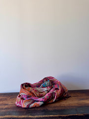 Colorful patterned fabric on a wooden surface with a white background