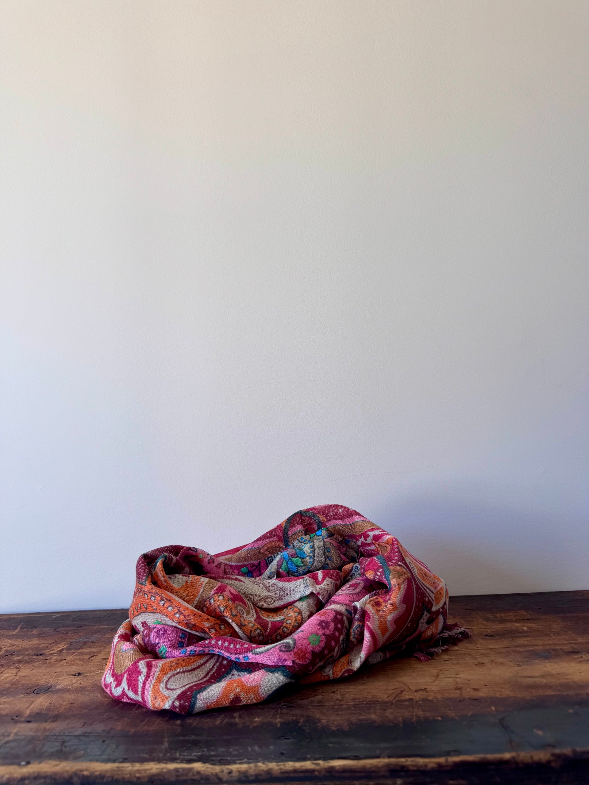 Colorful patterned fabric on a wooden surface with a white background