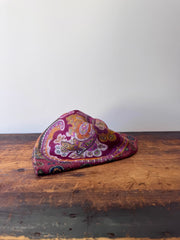 Colorful patterned scarve on a wooden surface with a white background