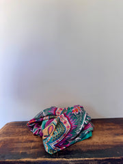 Colorful patterned fabric on a wooden surface with a white background
