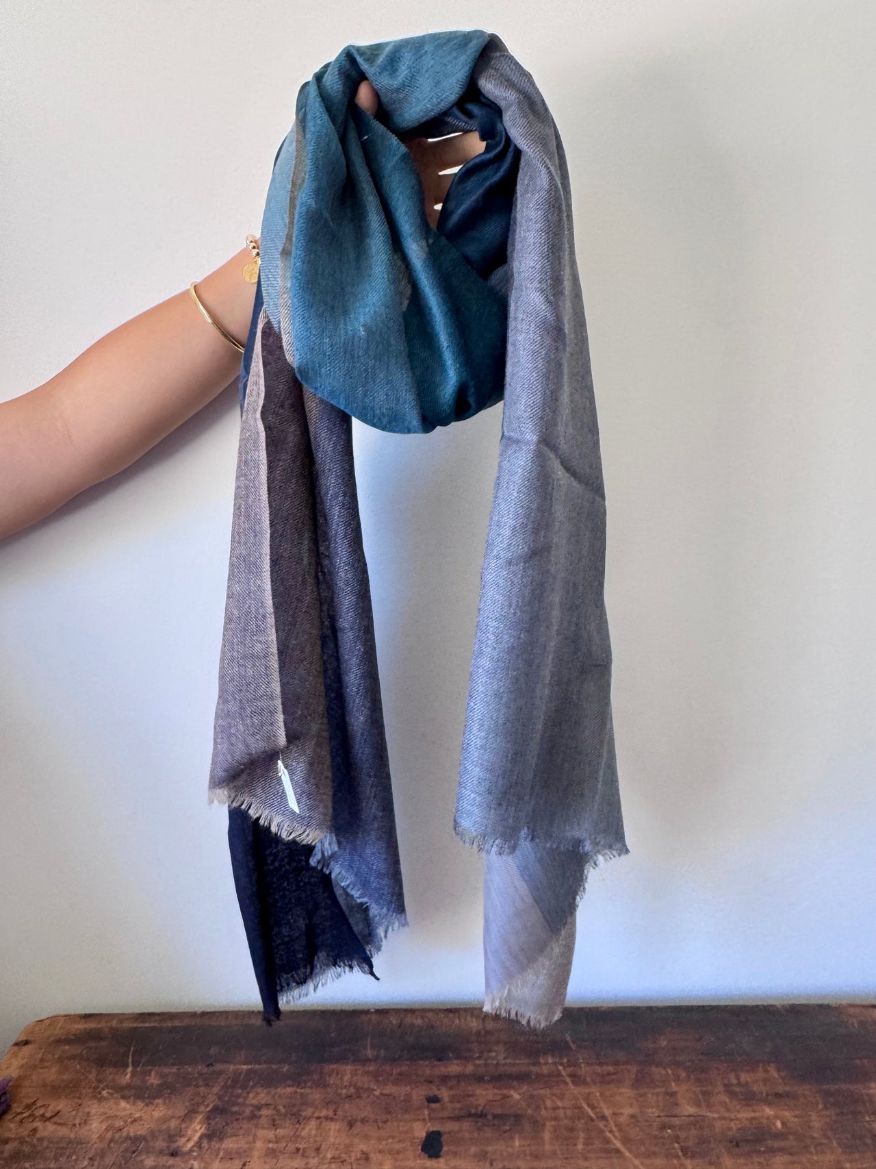Blue and gray scarf draped over a mannequin against a white background