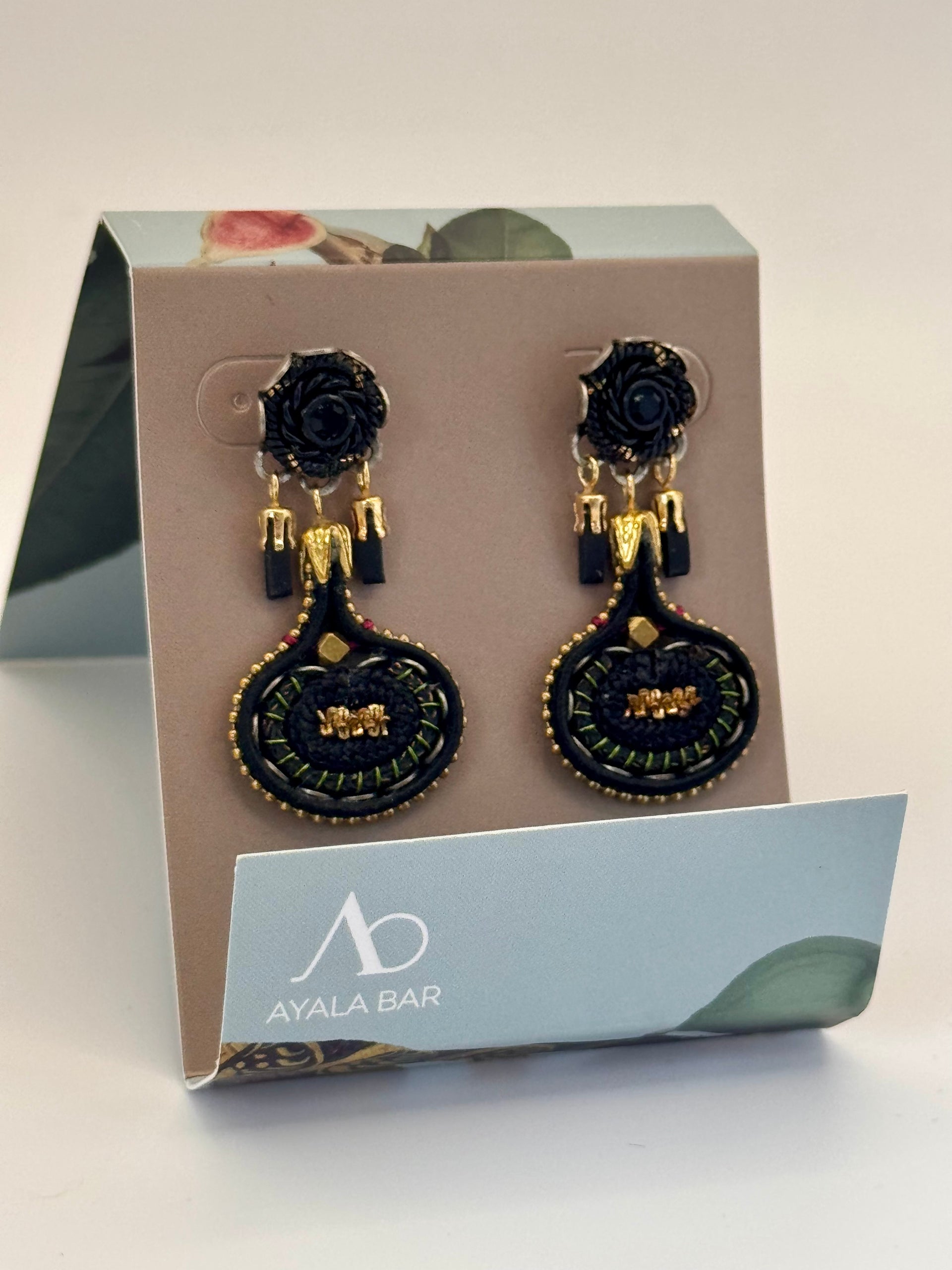 Black and gold earrings on a branded card with Ayala Bar logo.