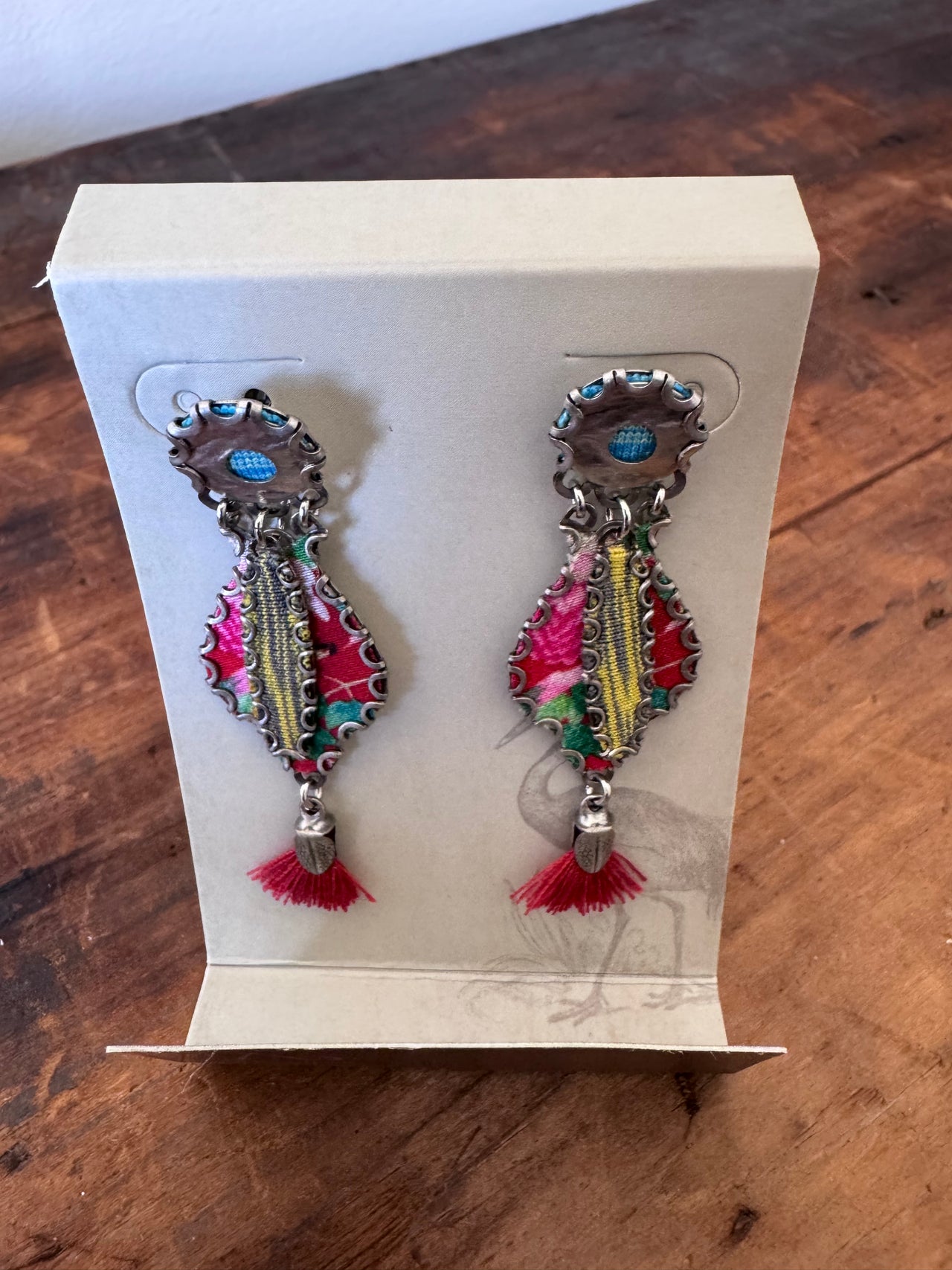 Colorful earrings with tassels on a wooden surface