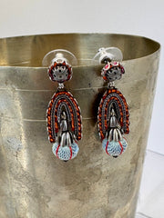 Pair of colorful earrings on a metallic surface