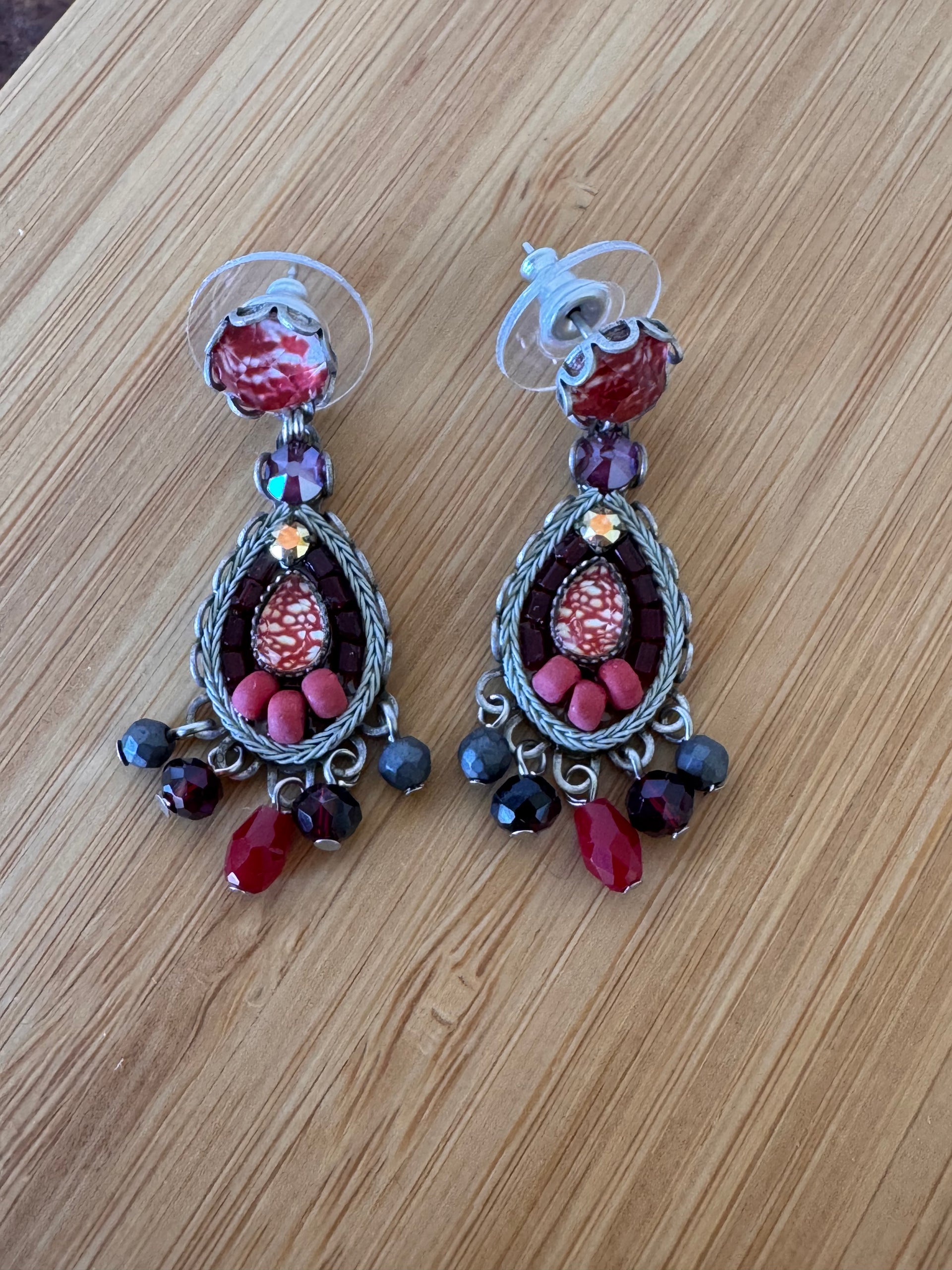 Pair of decorative earrings with beads on a wooden surface
