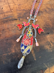 Decorative necklace with colorful beads and butterfly charms on a wooden surface