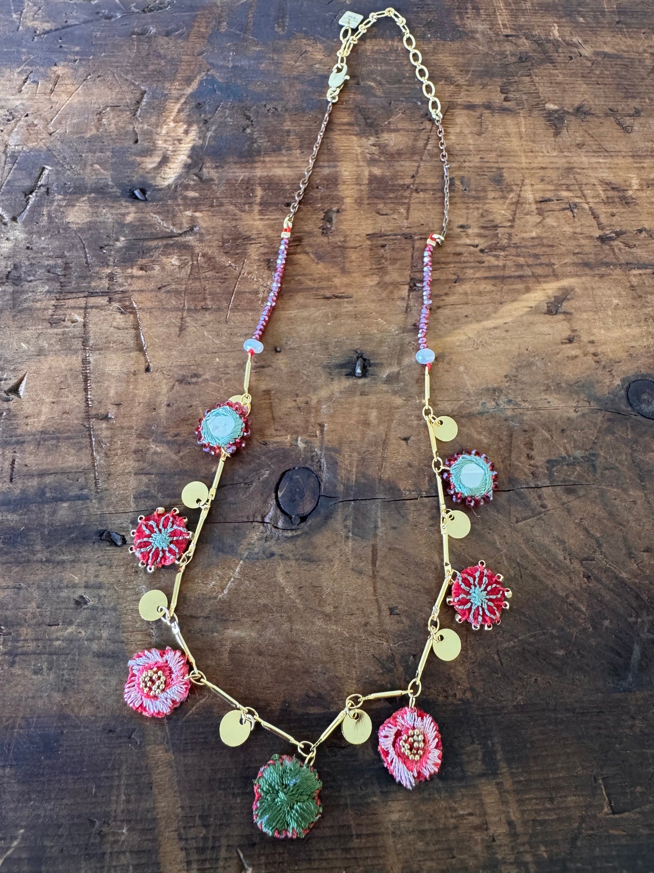 Necklace with floral charms on a wooden surface