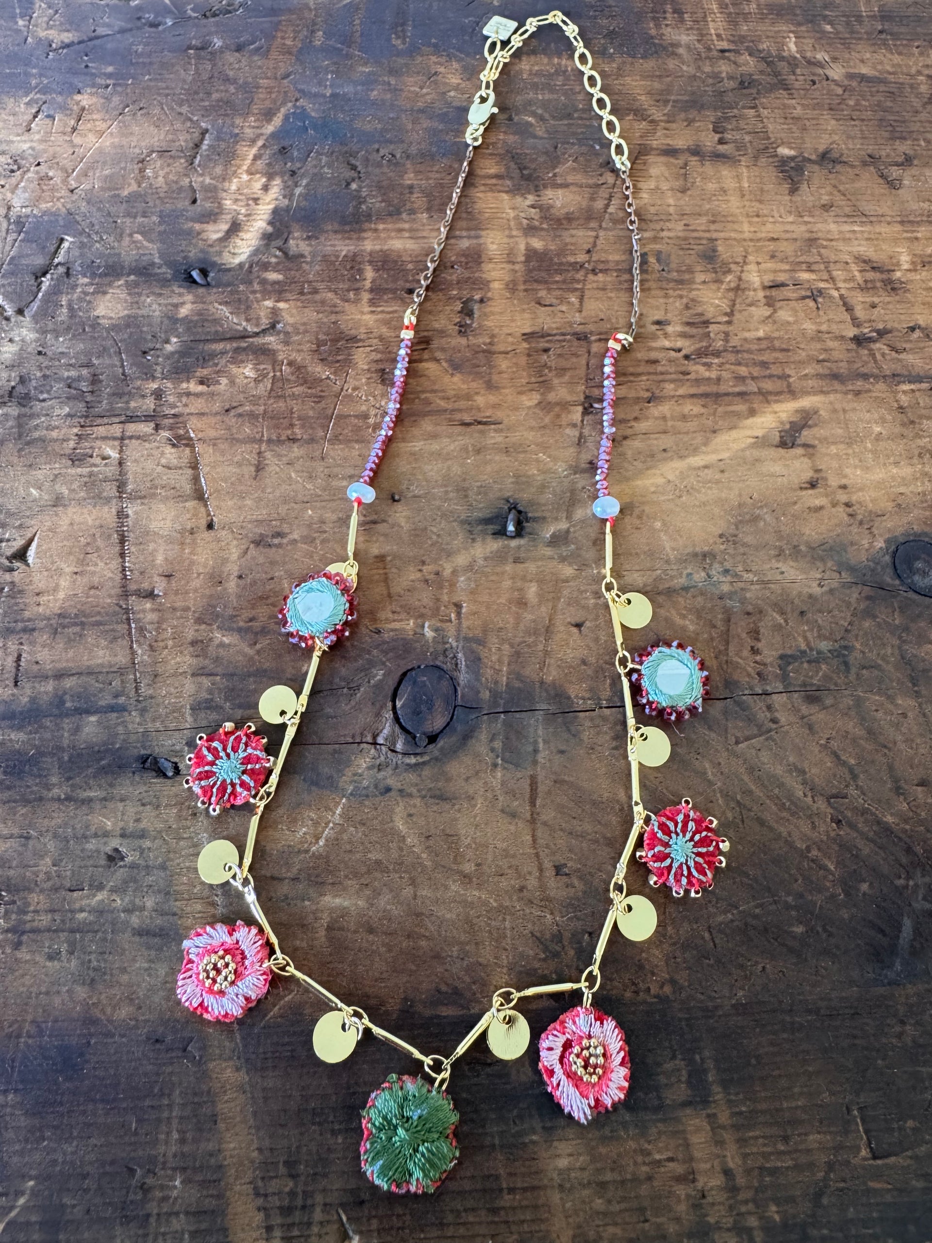 Necklace with floral charms on a wooden surface