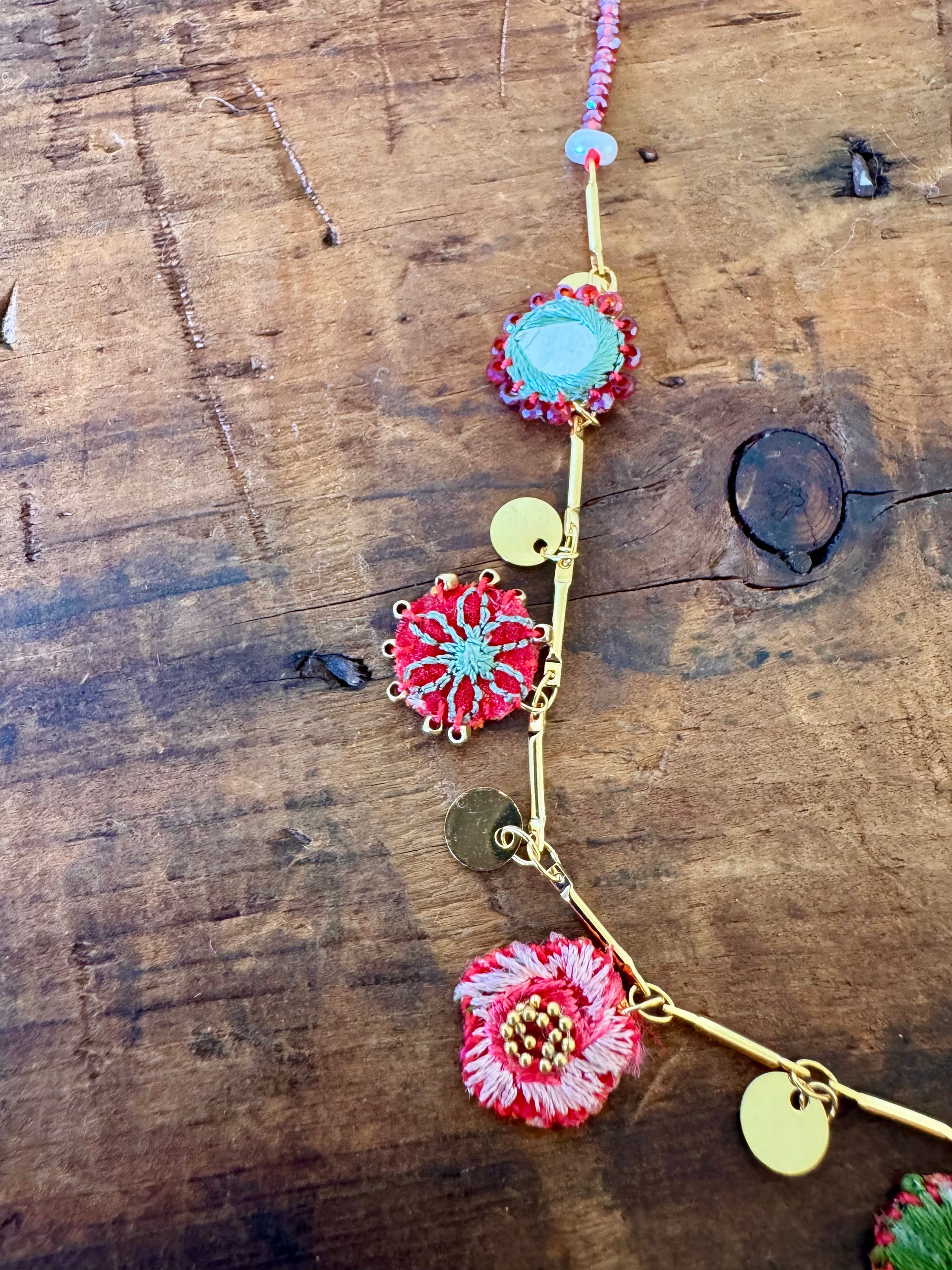 Necklace with floral pendants on a wooden surface