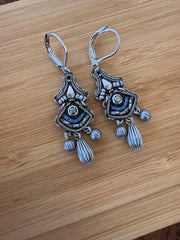Pair of silver earrings on a wooden surface