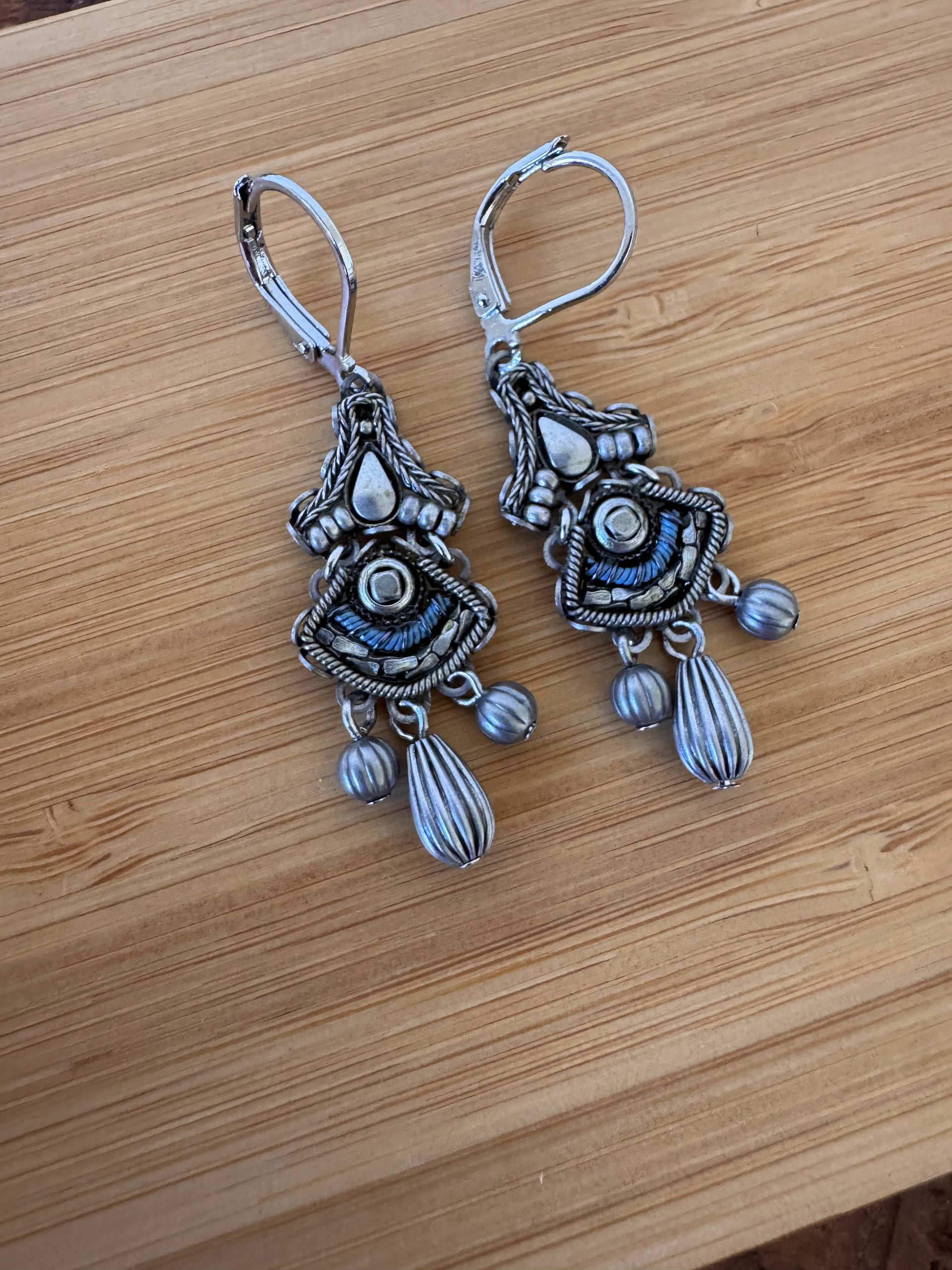 Pair of silver earrings on a wooden surface