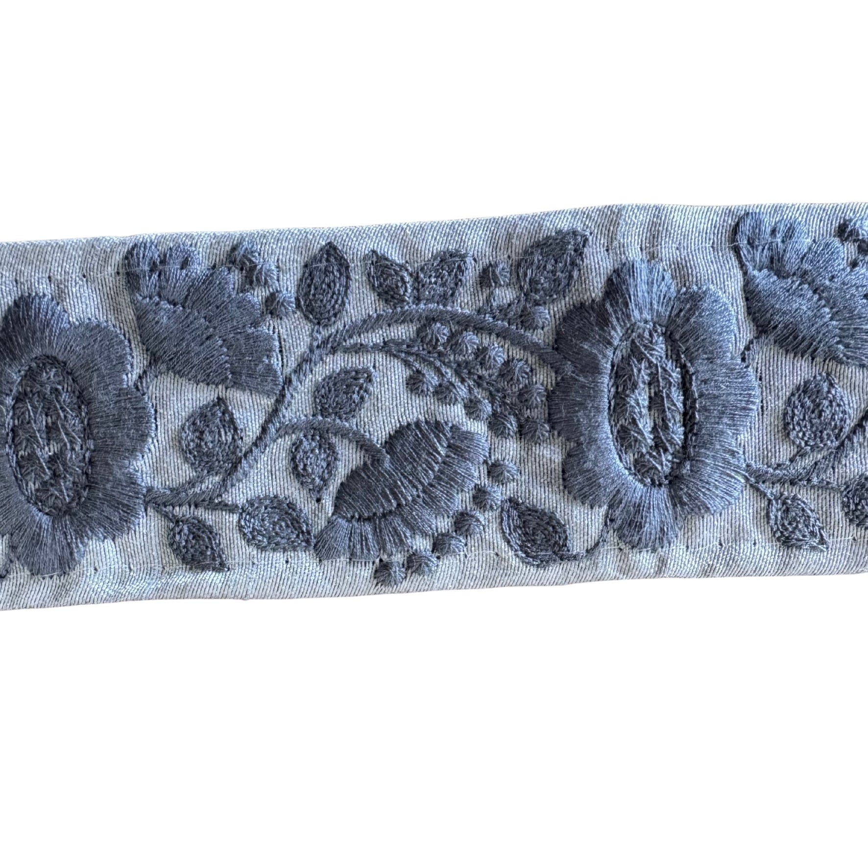 Embroidered floral pattern on a blue fabric strip