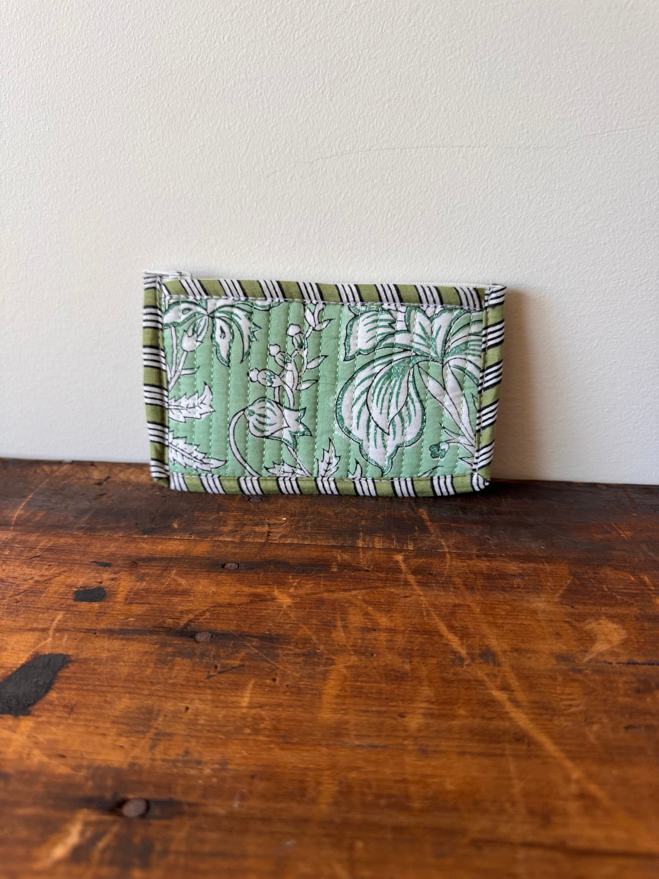 Green patterned fabric folded neatly on a wooden surface