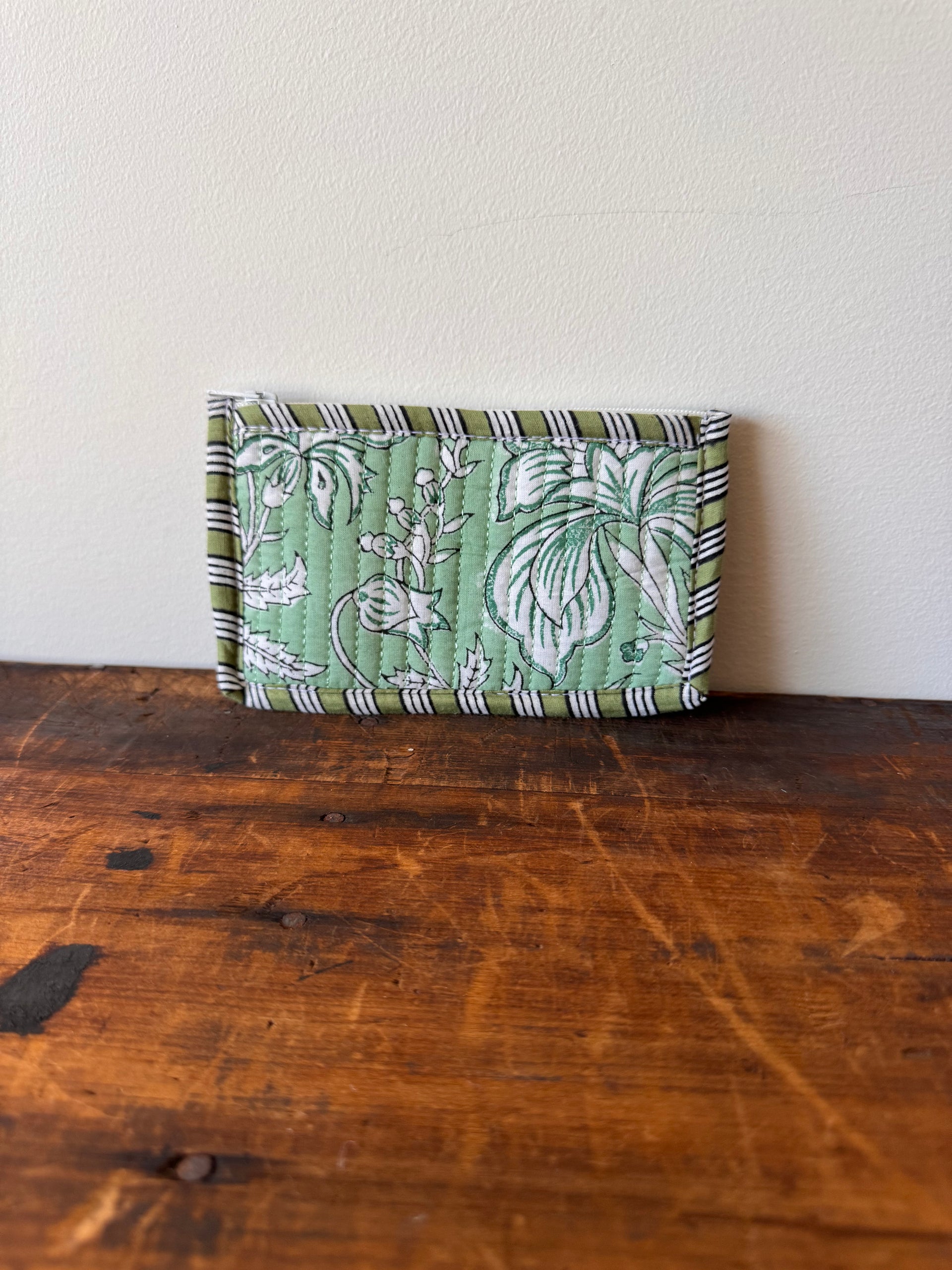 Green patterned fabric folded neatly on a wooden surface