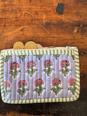 Floral patterned pouch with green stripes on a wooden surface