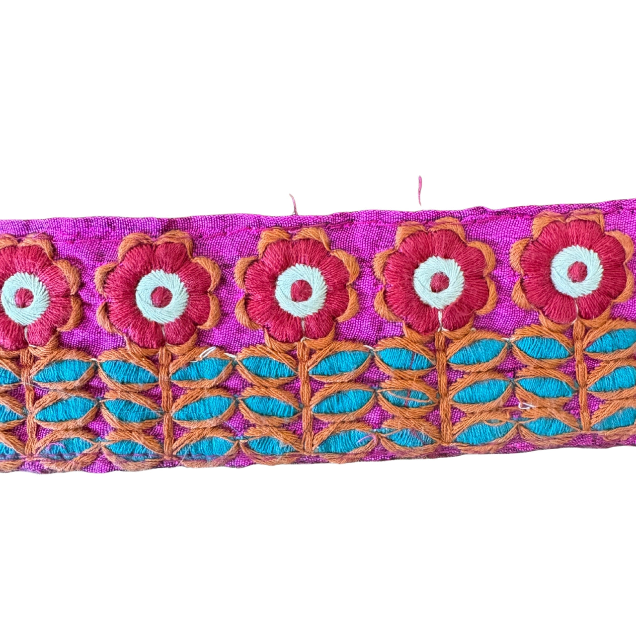 Embroidered fabric strip with floral design on a pink background