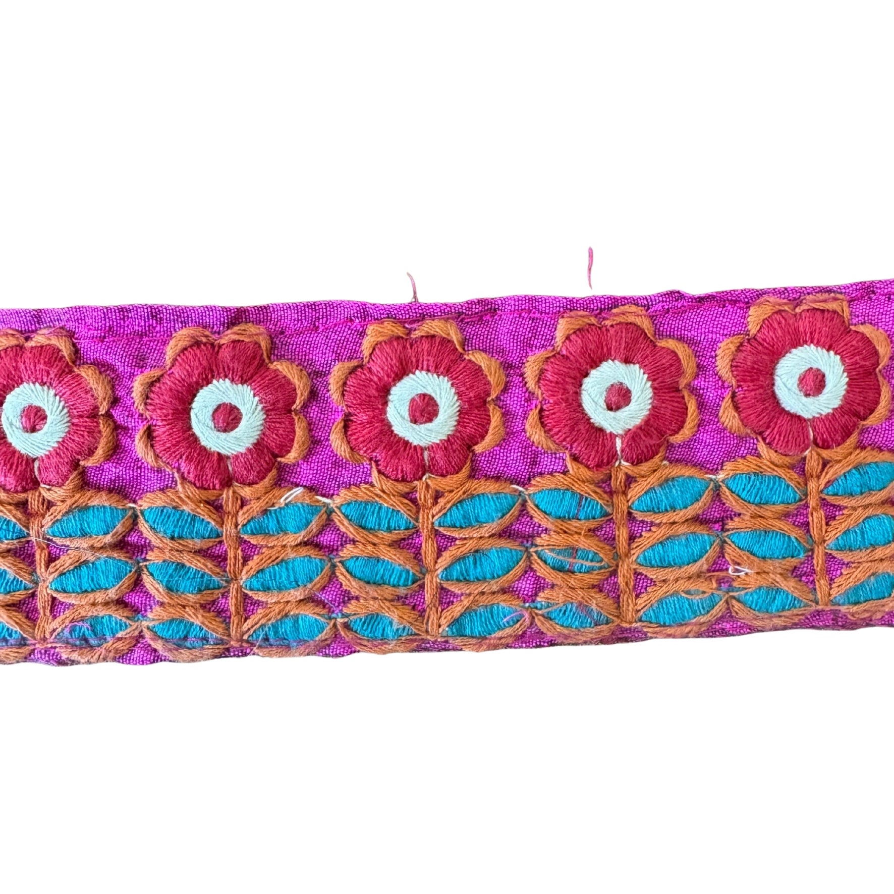 Embroidered fabric strip with floral design on a pink background