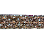 Decorative ribbon with intricate patterns and beads on a white background