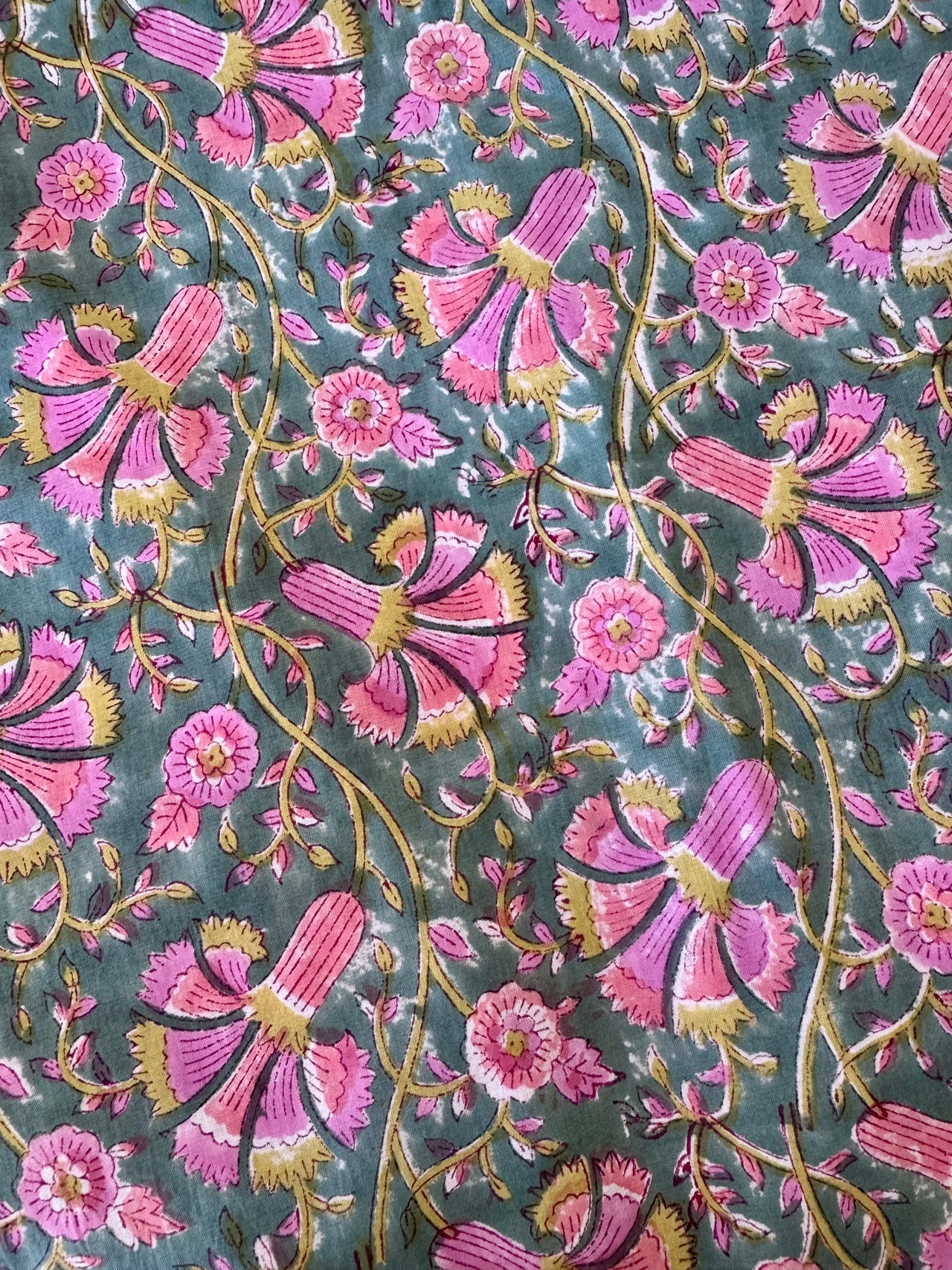 Close-up of a floral pattern with pink flowers and green leaves on a dark background