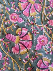 Close-up of a floral pattern with pink flowers and green leaves on a textured surface.