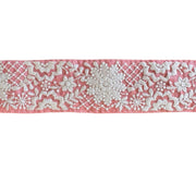 Embroidered lace trim on a pink background