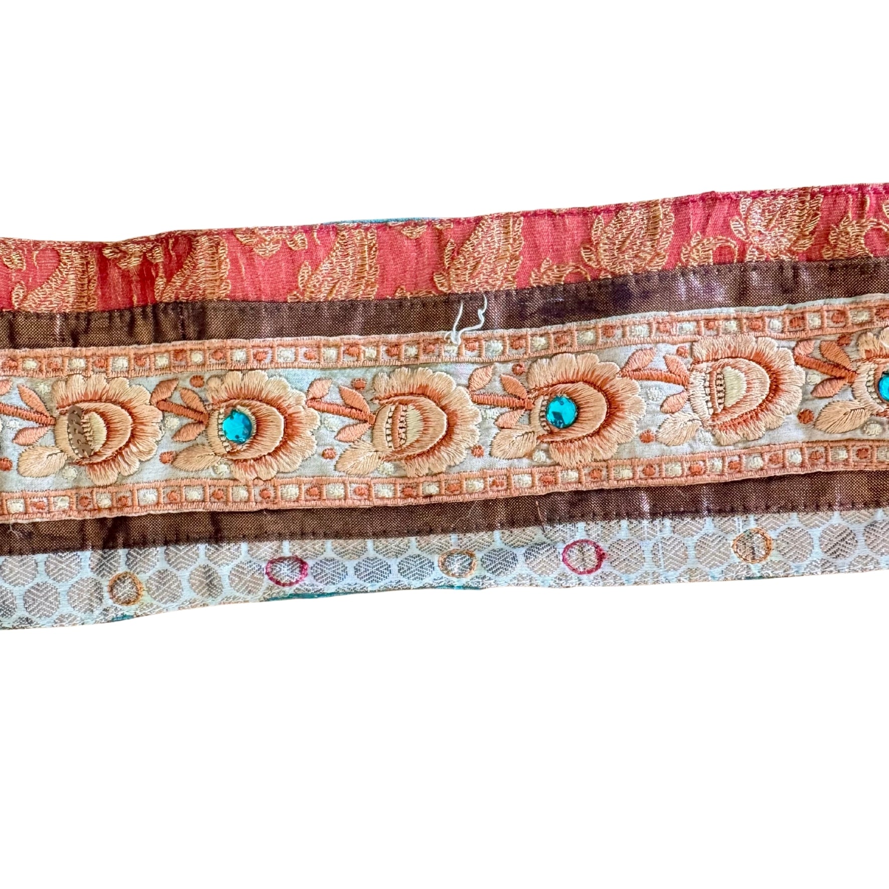 Decorative fabric strip with floral patterns and turquoise stones on a white background