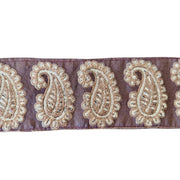Decorative ribbon with gold paisley patterns on a purple background