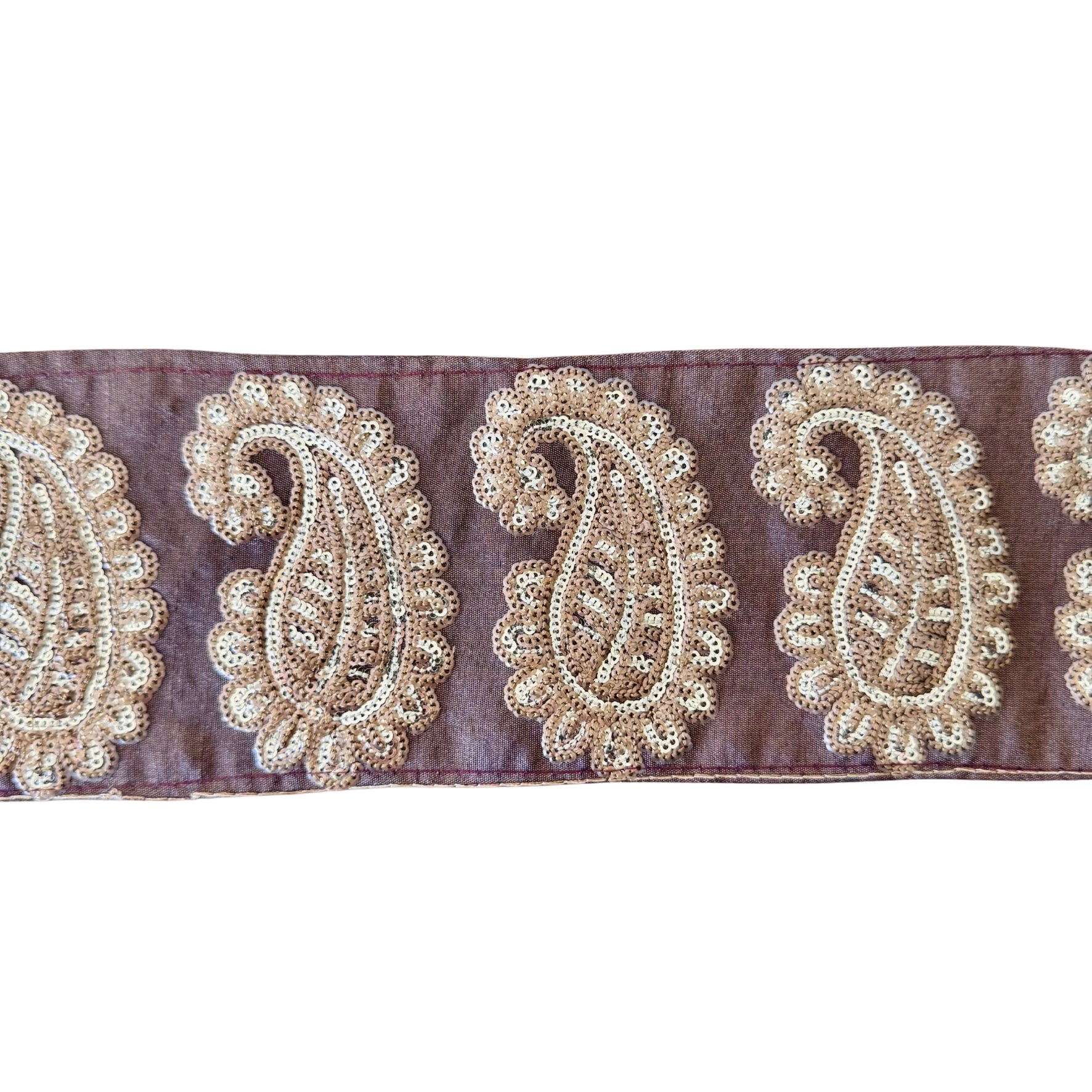 Decorative ribbon with gold paisley patterns on a purple background