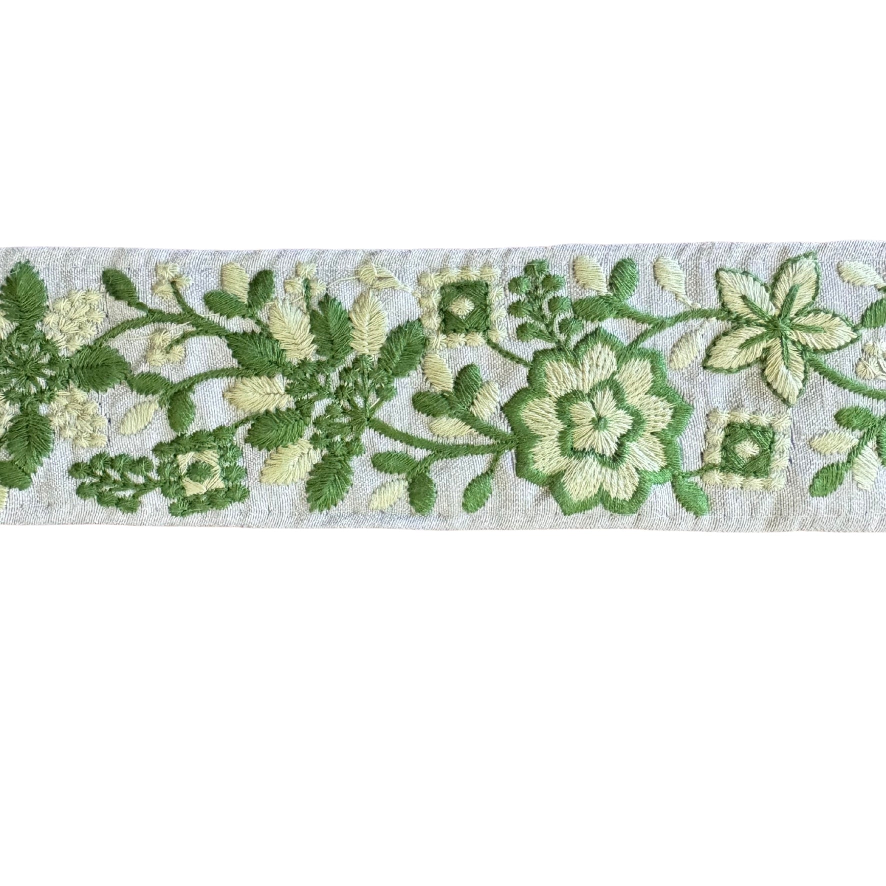 Embroidered floral pattern with green and white flowers on a textured background