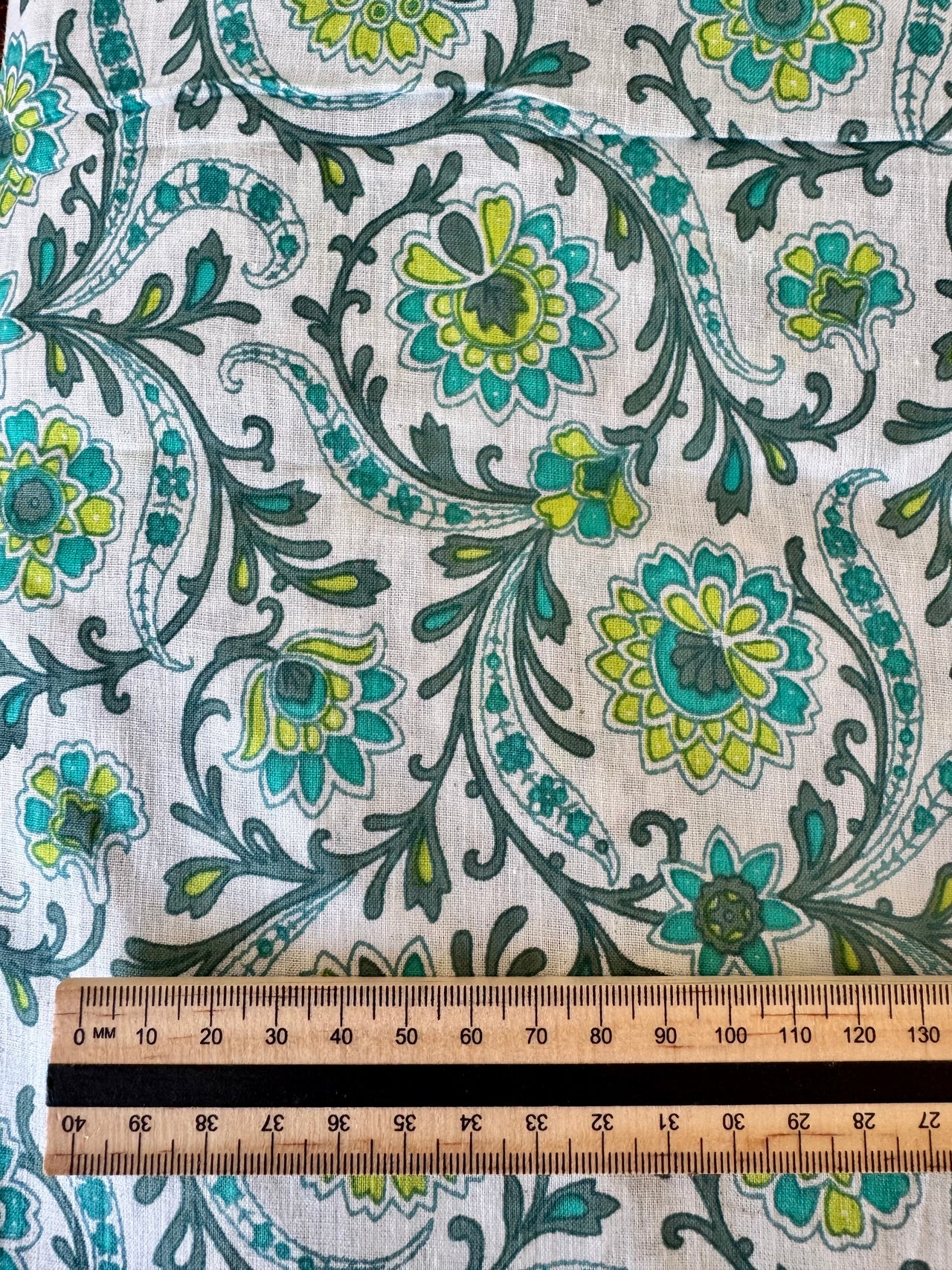 Floral patterned fabric with a ruler for scale on a white background