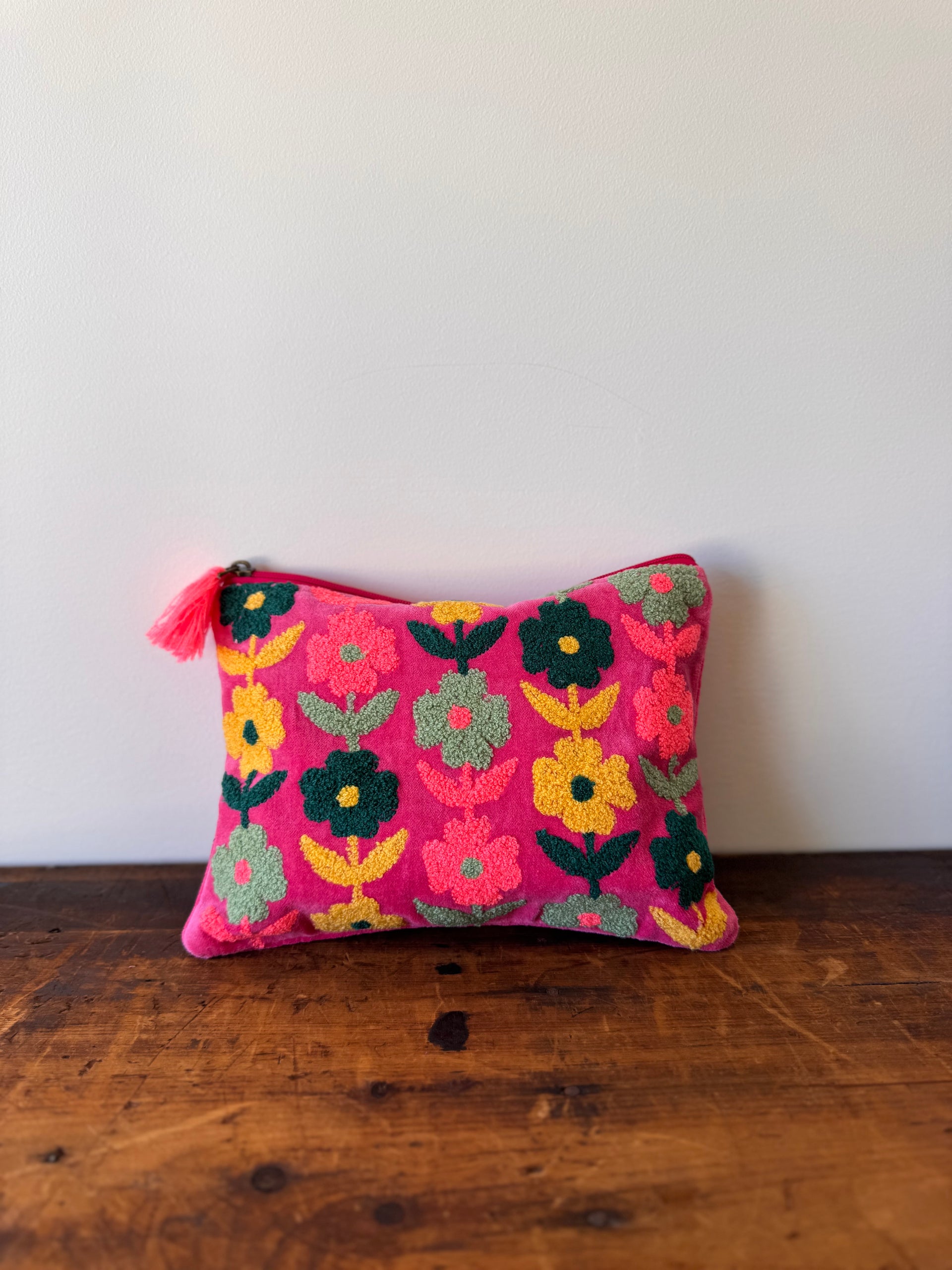 Decorative pillow with floral pattern on a wooden surface
