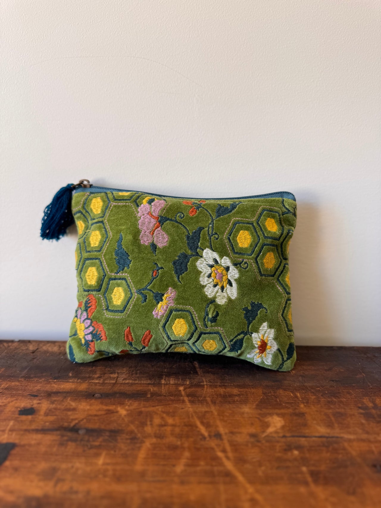 Embroidered pouch with floral patterns on a wooden surface