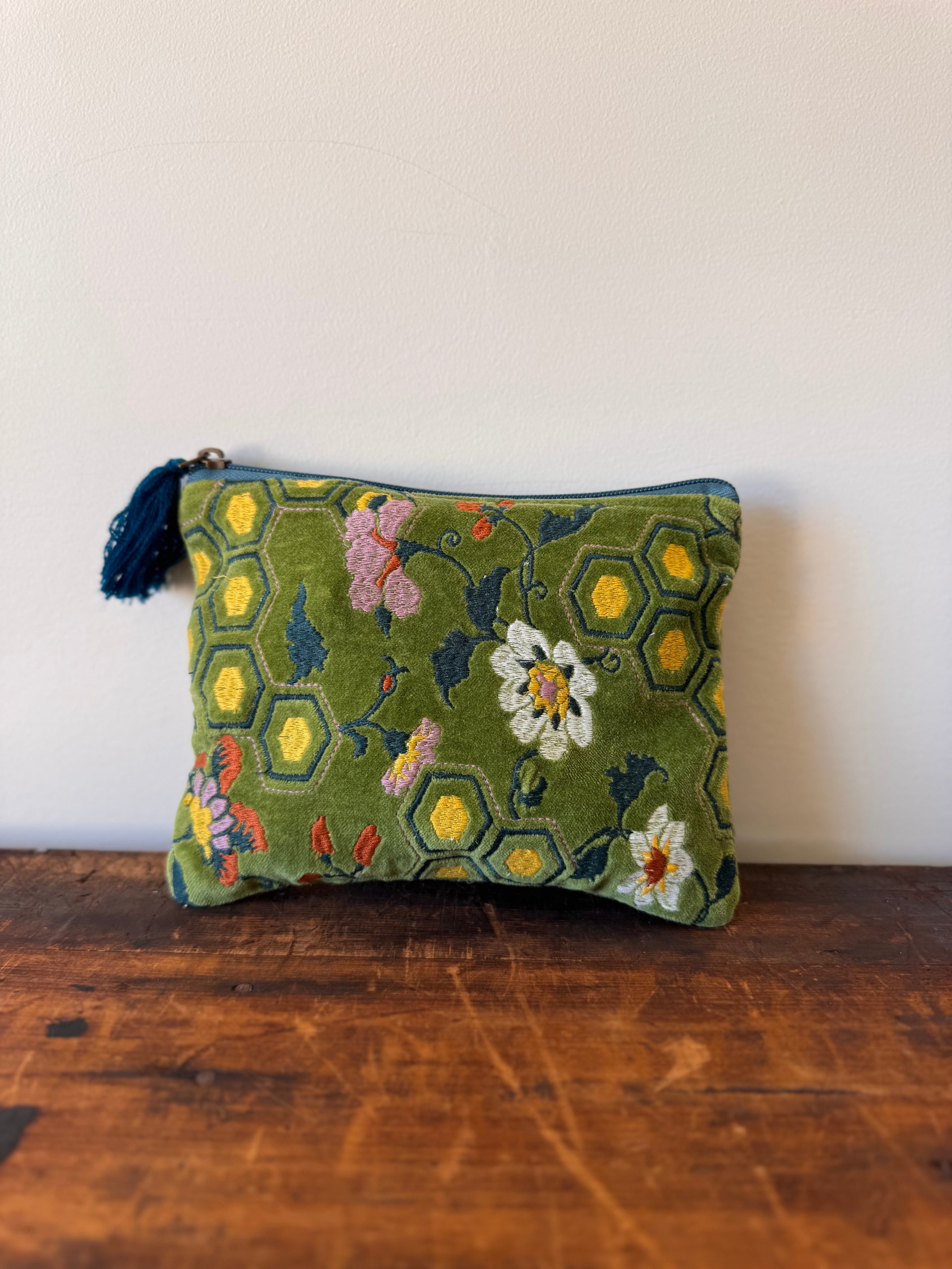 Embroidered pouch with floral patterns on a wooden surface