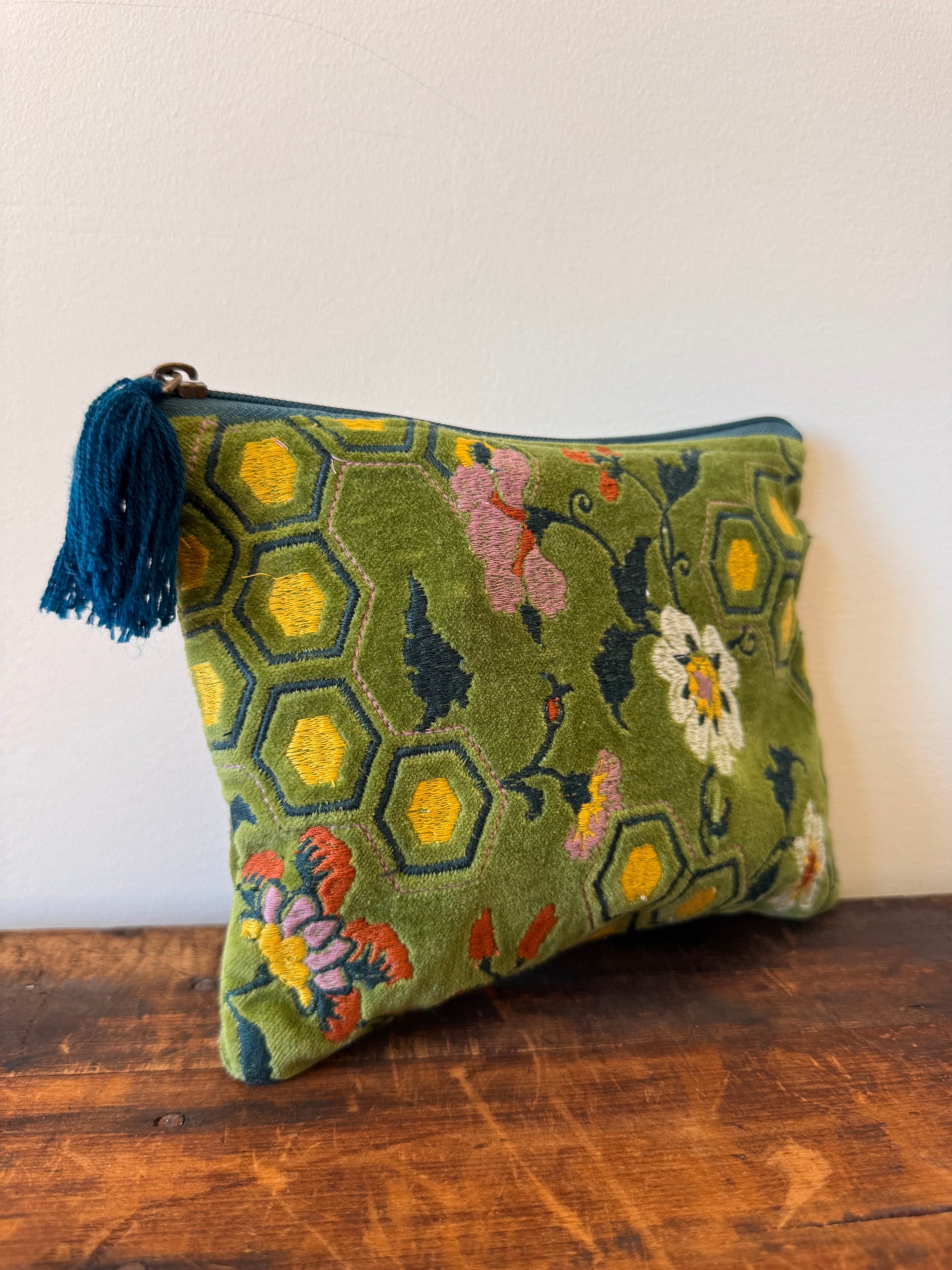 Decorative pillow with floral and geometric pattern on a wooden surface