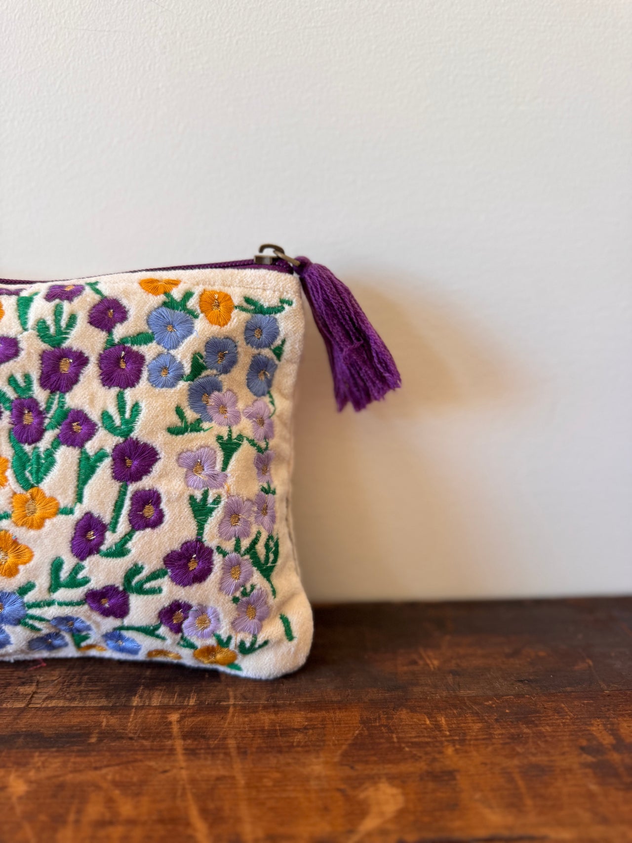 Embroidered pouch with floral patterns on a wooden surface