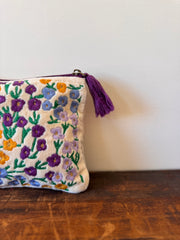 Embroidered pouch with floral patterns on a wooden surface