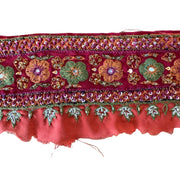 Decorative fabric border with floral patterns and beads on a white background