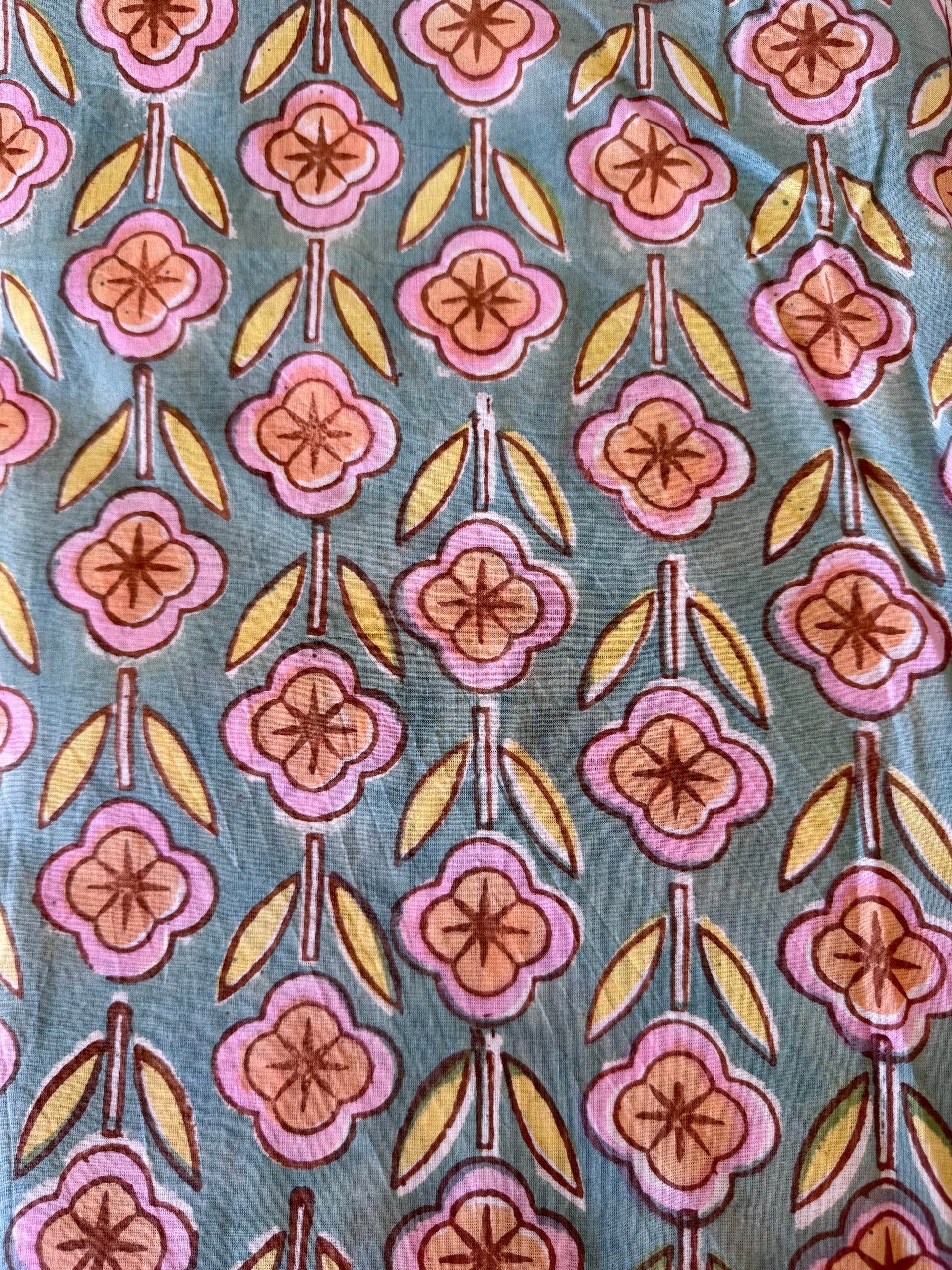 Patterned fabric with pink and orange flowers on a blue background