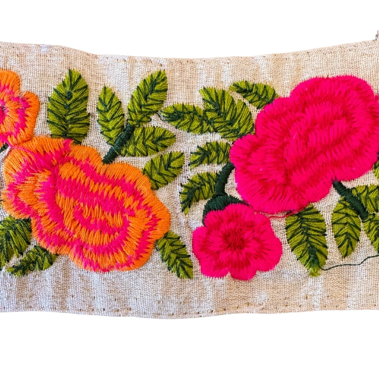 Embroidered fabric with pink and orange flowers on a beige background