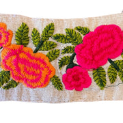 Embroidered fabric with pink and orange flowers on a beige background