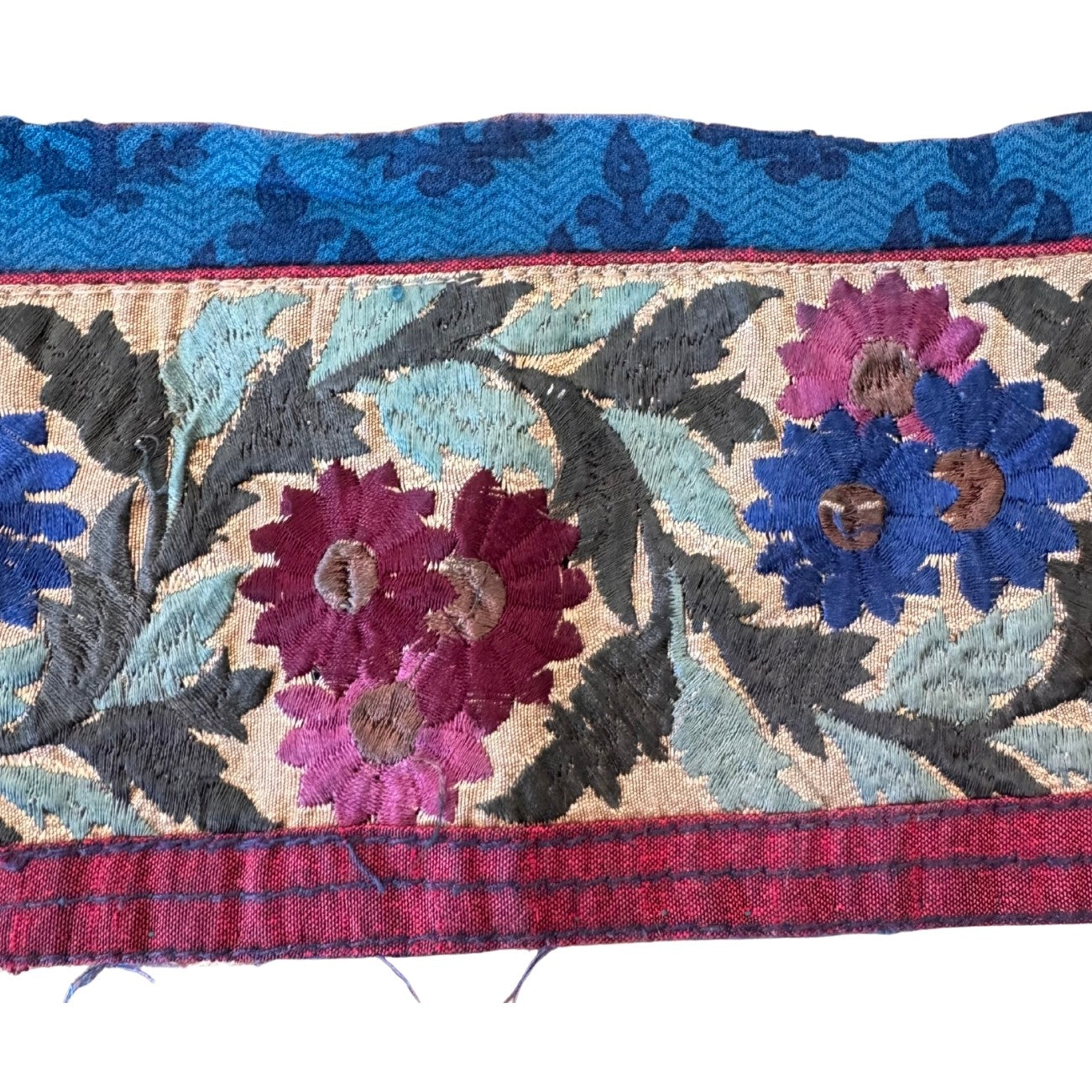 Embroidered fabric strip with floral patterns on a white background